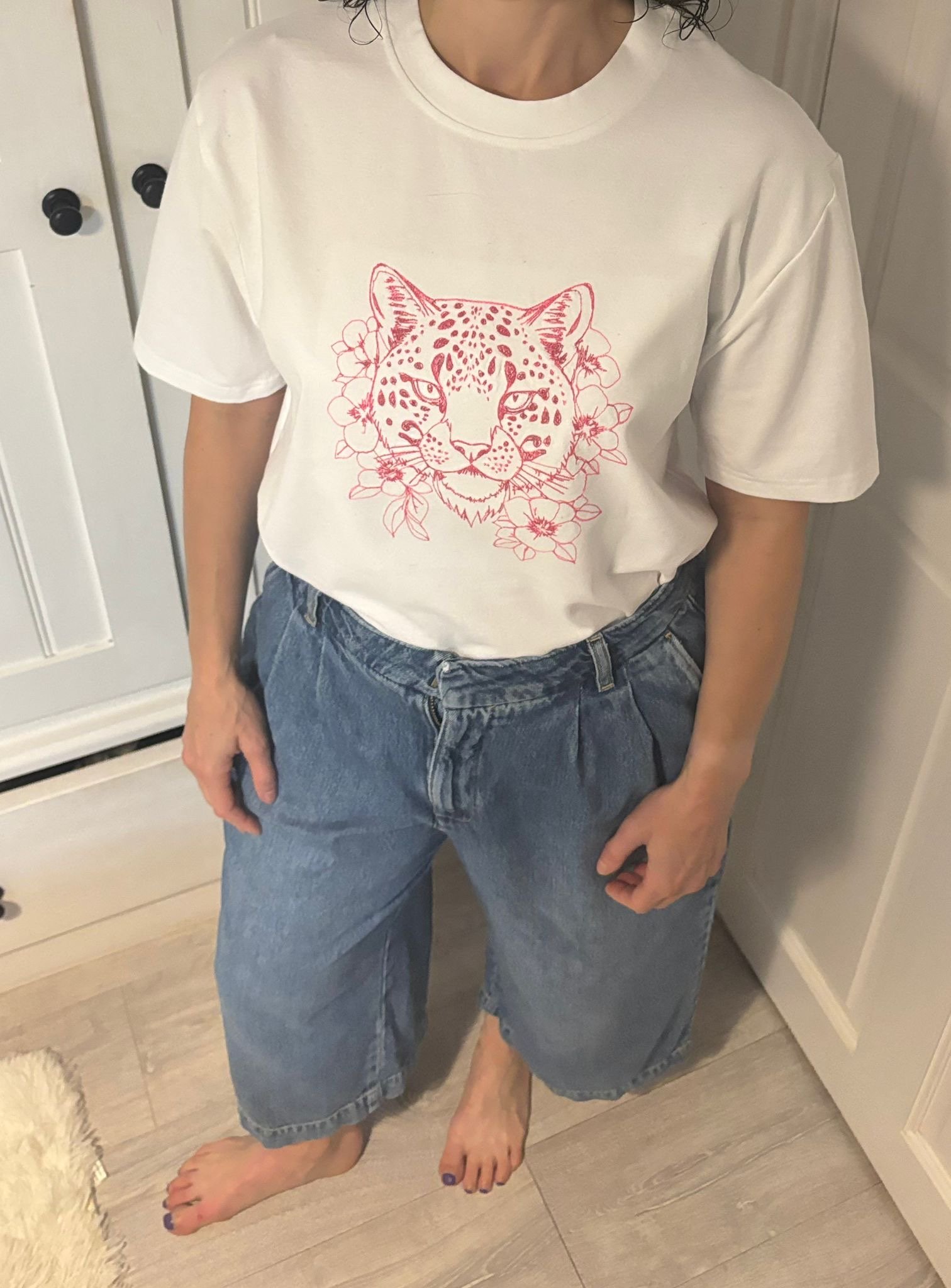 Person wearing handmade big cat floral embroidered sweatshirt by Lucky Threads