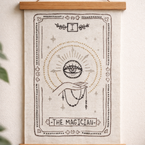 Hand-stitched Magician tarot wall hanging on an 11 × 14 inch (28 × 36 cm) canvas, shown unframed with free-motion embroidery and hand beading.