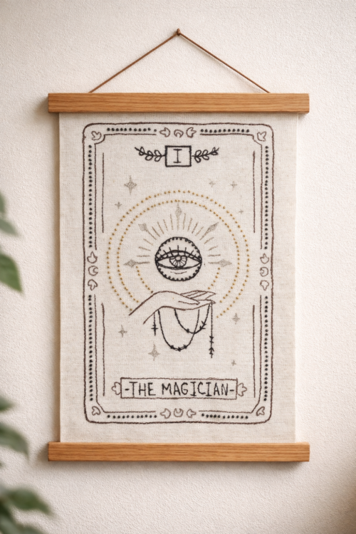 Hand-stitched Magician tarot wall hanging on an 11 × 14 inch (28 × 36 cm) canvas, shown unframed with free-motion embroidery and hand beading.