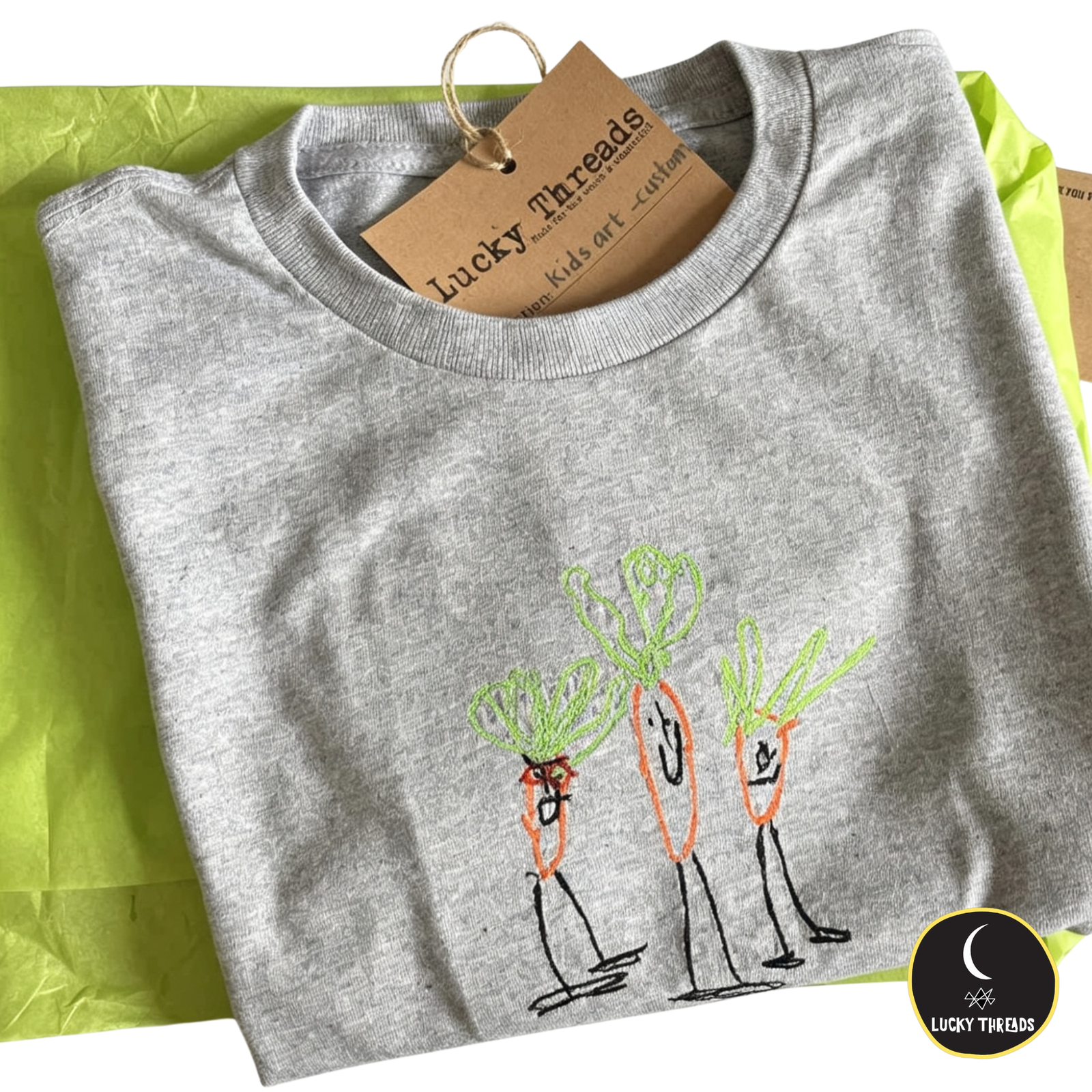 Flatlay of custom kids art T-shirt with stitched character design