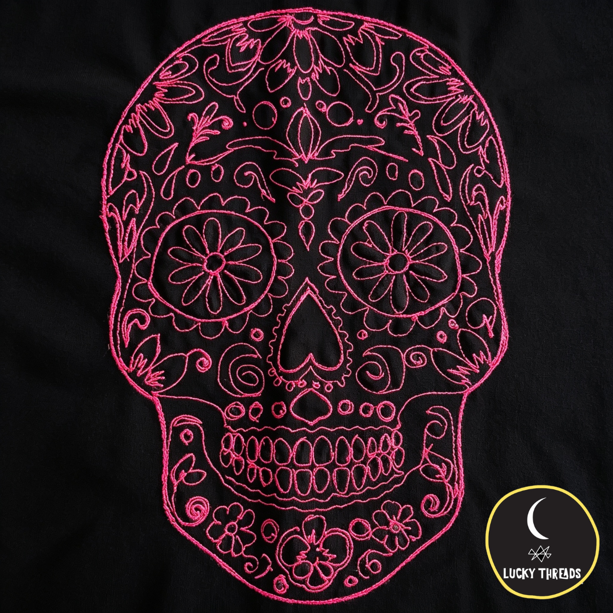 Hot pink skull embroidered design on black tee